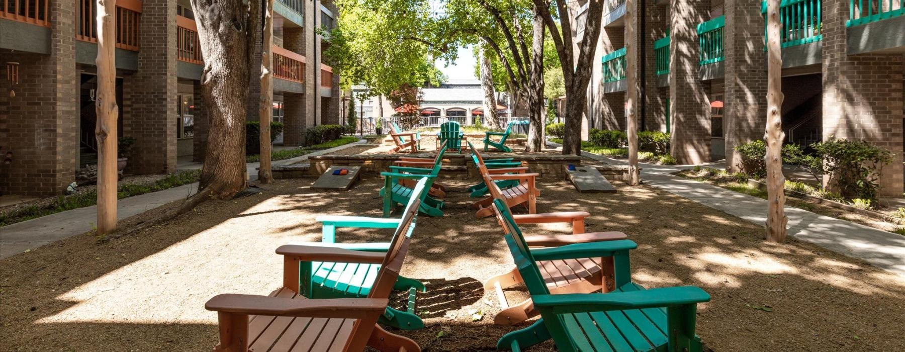 a row of green chairs on a sidewalk